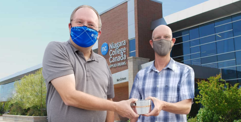 Dr. Allan Spence, WAMIC research lead, giving the prototype developed to Kevin LeBlanc, Brilliant Photonics CEO.