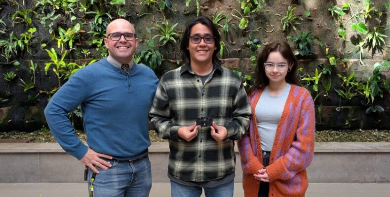 Principal Investigator Wladimir Figueiredo with student researchers Bryan Díaz Moscoso and Varvara Nefedova showing a 3D-printed optimized part of the Vortex Press™.