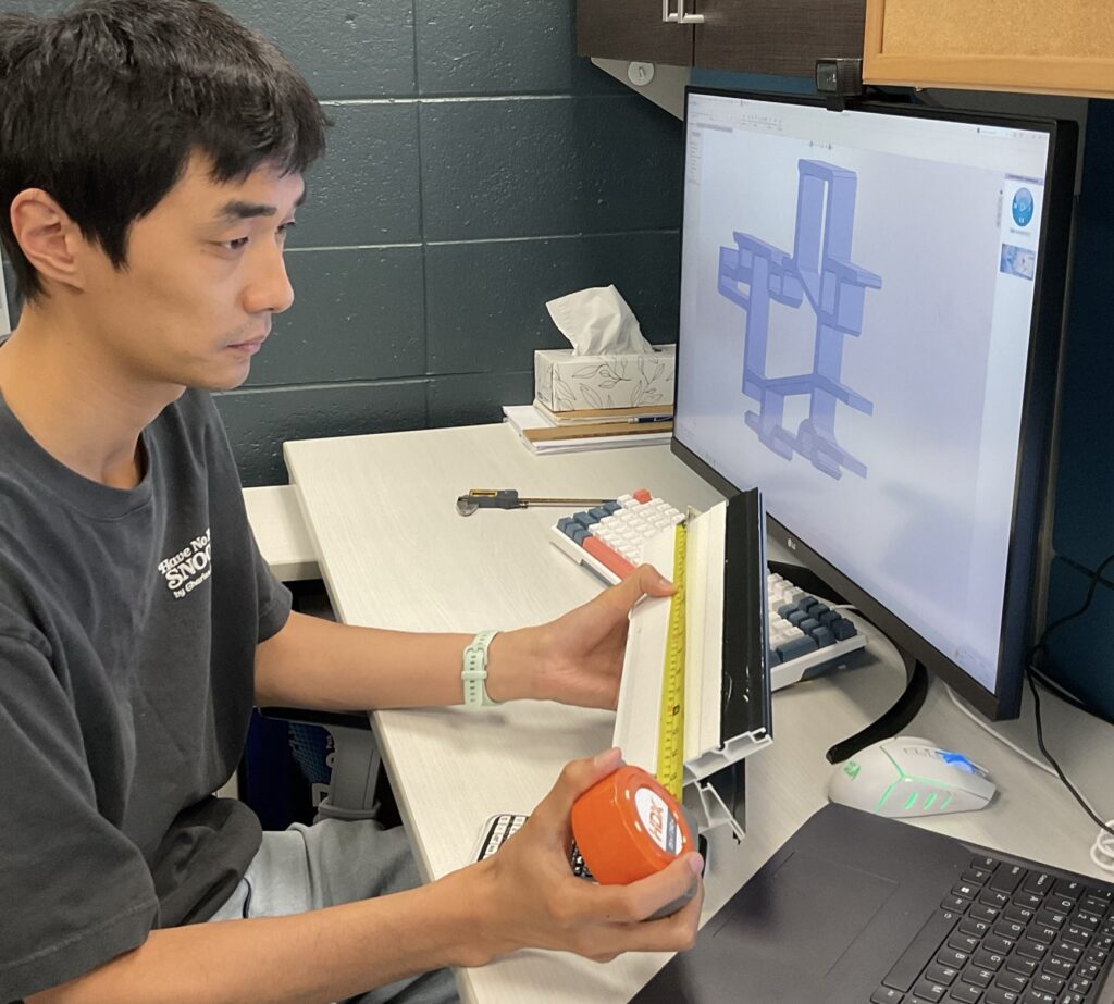 CIM team member measuring a window frame profile against its 3d model for the project.